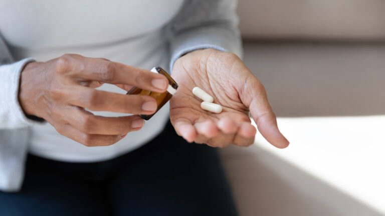 Close up of girl hold pills and jar in her hands